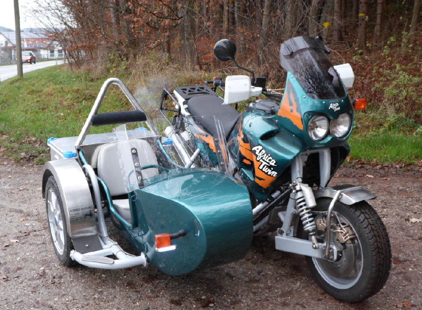 Ein Motorrad mit Beiwagen, das auf einer Straße geparkt ist und sein Vintage-Design und seine Chromdetails zur Schau stellt.